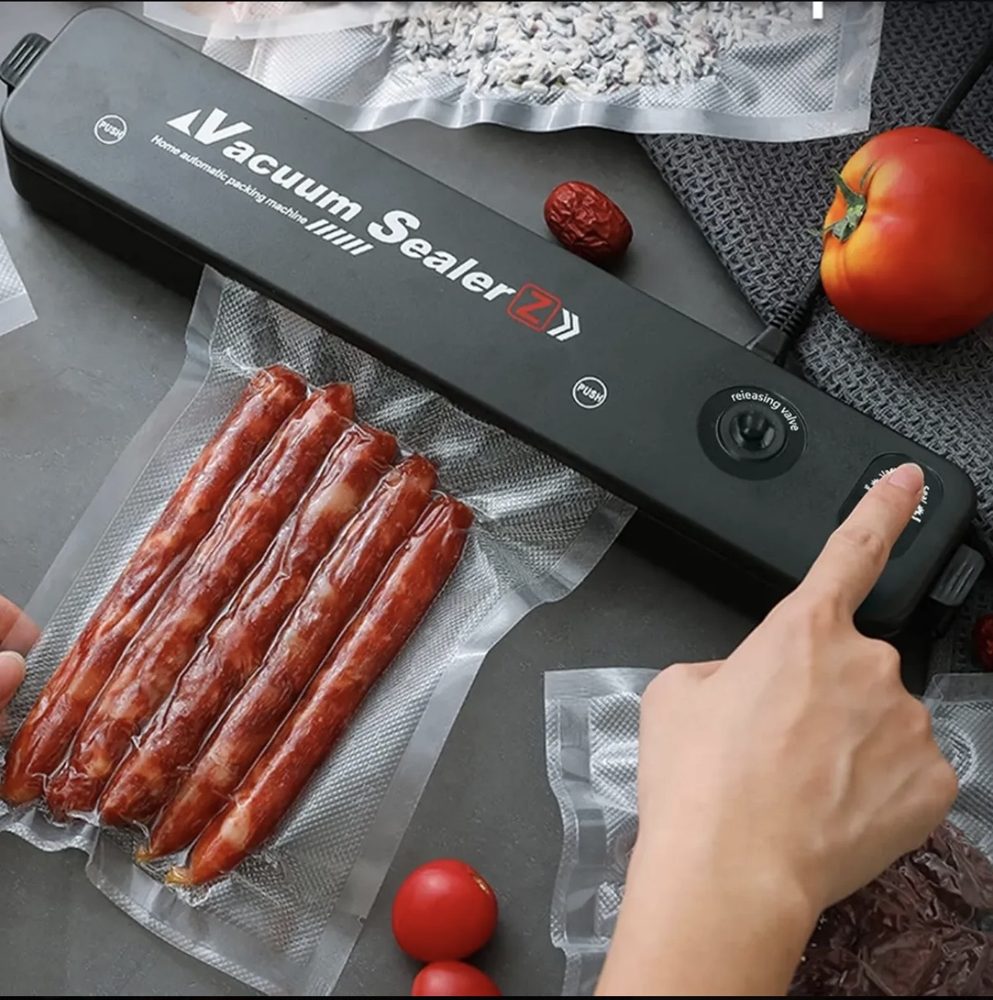 Selladora al vacío con bolsas selladas de carne y verduras